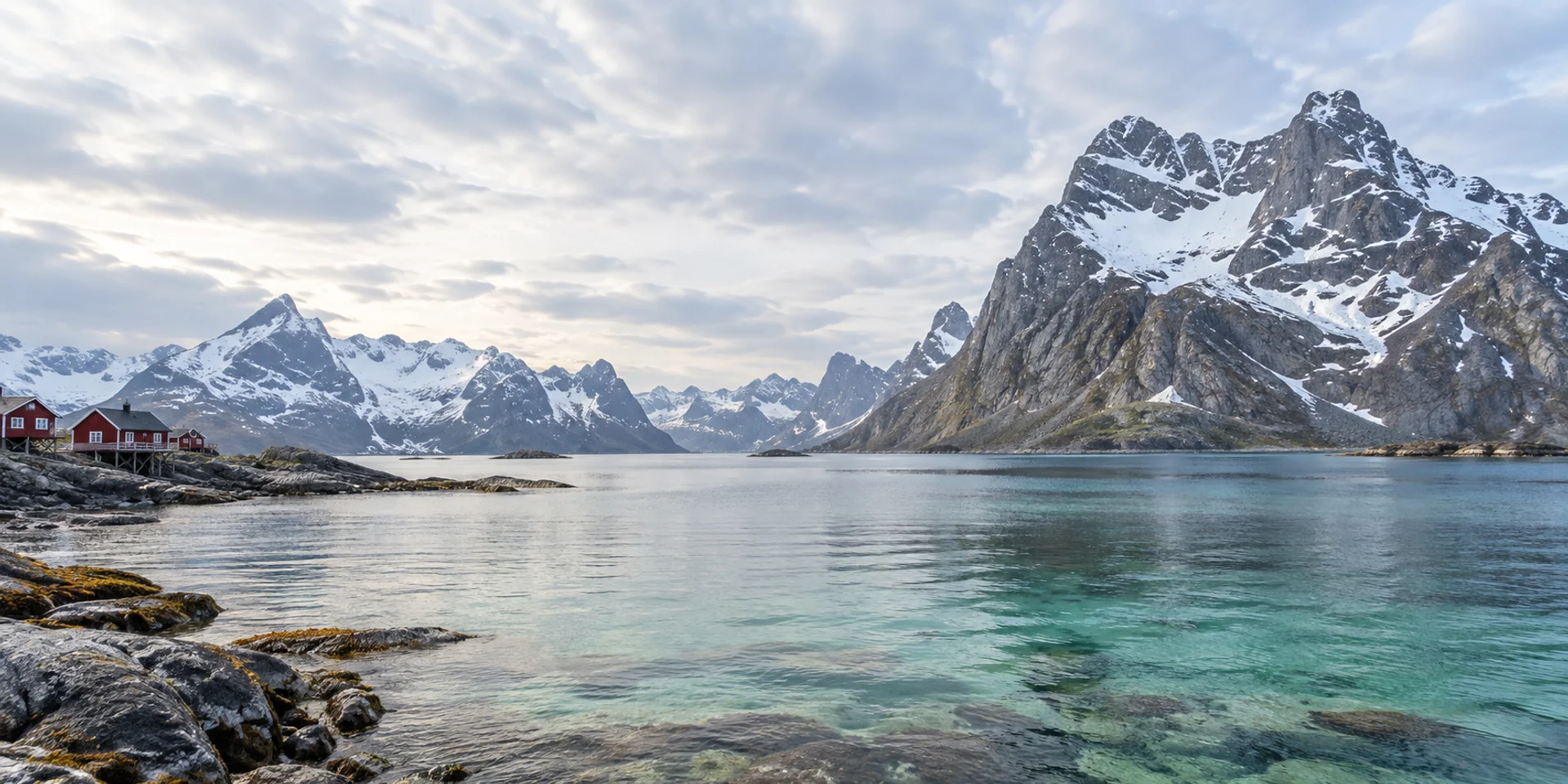Ruhiges Wasser an einer nordischen Küste, dahinter schneebedeckte Berge. Generiertes Landschaftsmotiv.